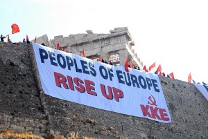 時計の針が逆戻り、ギリシャ炎上とその背後に見えるもの、共産党系活動家は首都アテネの古代遺跡アクロポリスにあるパルテノン神殿前に「欧州の人民よ、立ち上がれ」との横断幕を掲げ抗議の意思